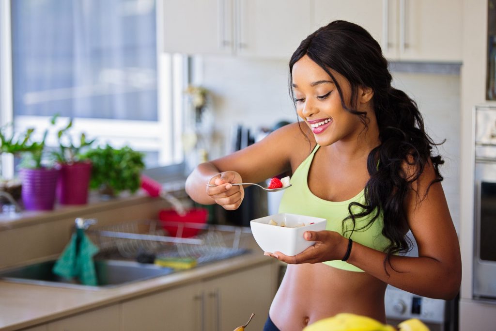 Jeune femme au régime qui se fait plaisir en mangeant un plat sain mais gourmand