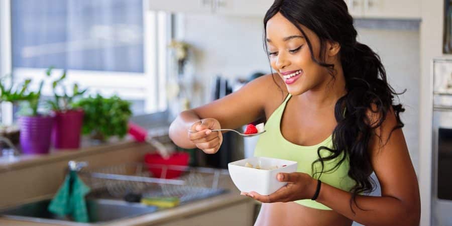 Jeune femme au régime qui se fait plaisir en mangeant un plat sain mais gourmand