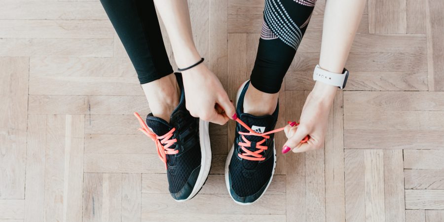 Jeune femme qui enfile ses baskets pour faire du sport et mincir